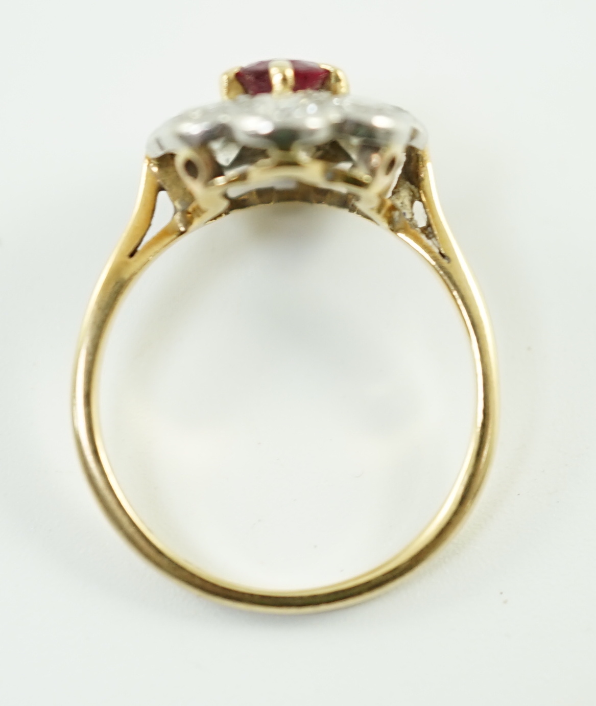 An 18ct gold, claw set single stone ruby and eight stone collet set diamond oval cluster ring